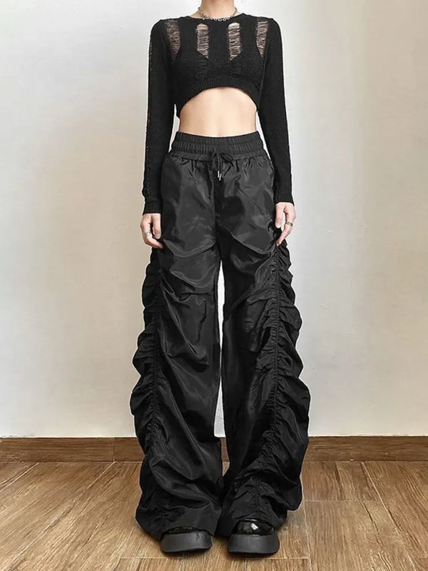 Distorted Reality Wide Leg Pants. These high-waisted pants have a stretchy waistband with adjustable ties, a ruched construction and baggy wide legs.