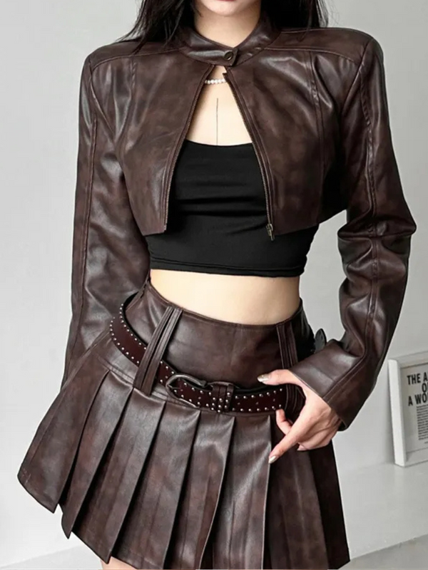 In The Moment Cropped Jacket has a vegan leather construction, a high neckline with snap button closure, long sleeves, a cropped fit and a front zipper closure.