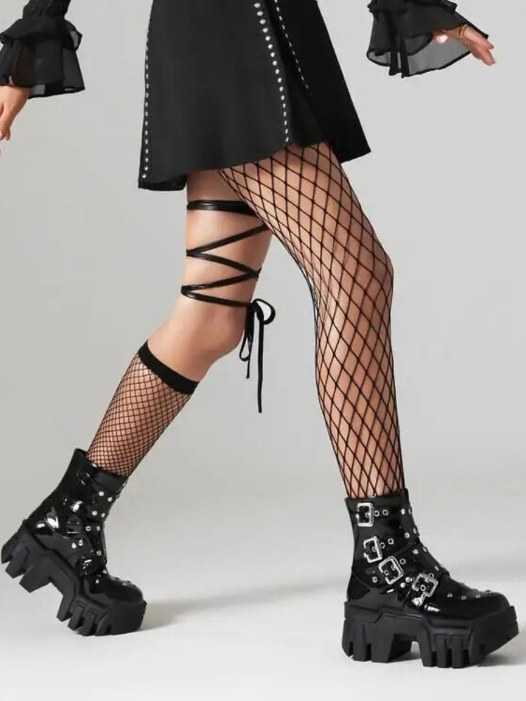 Rebel Core Ankle Platform Boots come in a patent vegan leather construction, with a treaded chunky heeled platform, buckle straps and eyelet details.