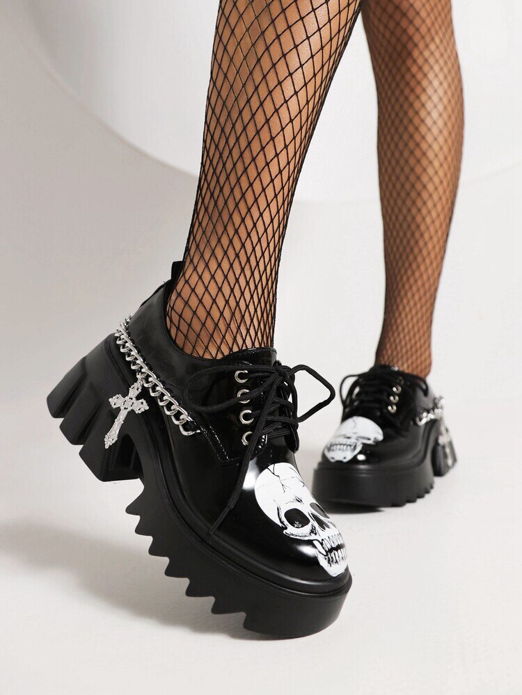 Make You Nervous Platform Sneakers. These platform sneakers have a vegan patent leather construction, chain with cross pendant hardware, adjustable lace-ups and skull graphics.