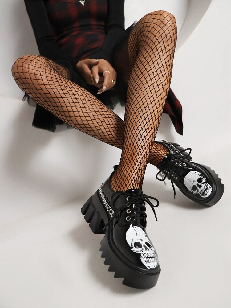 Make You Nervous Platform Sneakers. These platform sneakers have a vegan patent leather construction, chain with cross pendant hardware, adjustable lace-ups and skull graphics.
