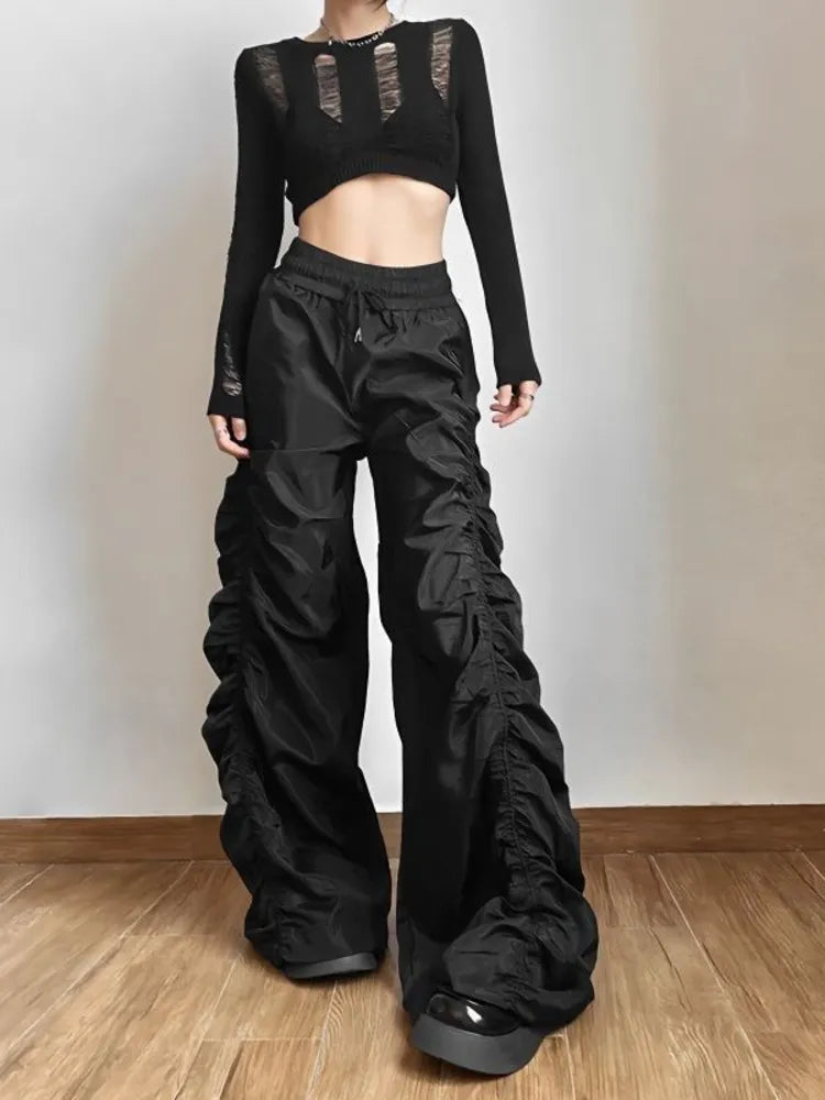 Distorted Reality Wide Leg Pants. These high-waisted pants have a stretchy waistband with adjustable ties, a ruched construction and baggy wide legs.
