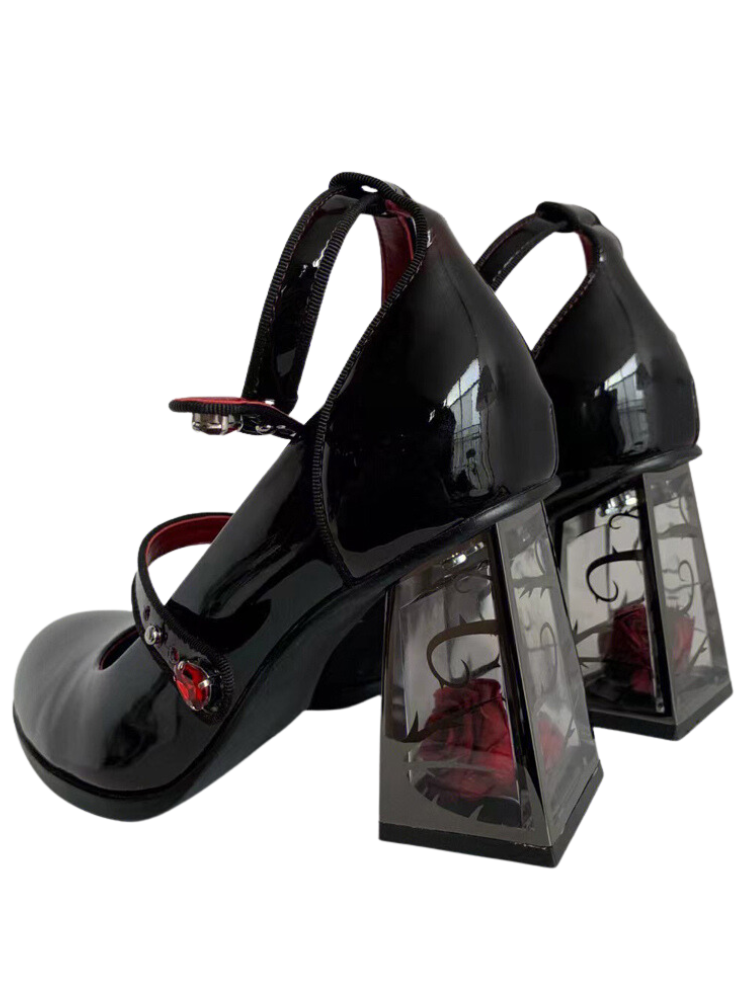 Magical Forecast Mary Janes. These mary janes have a red-black ombre patent vegan leather construction, transparent block heels with roses inside and adjustable buckle ankle straps with red rhinestones design.