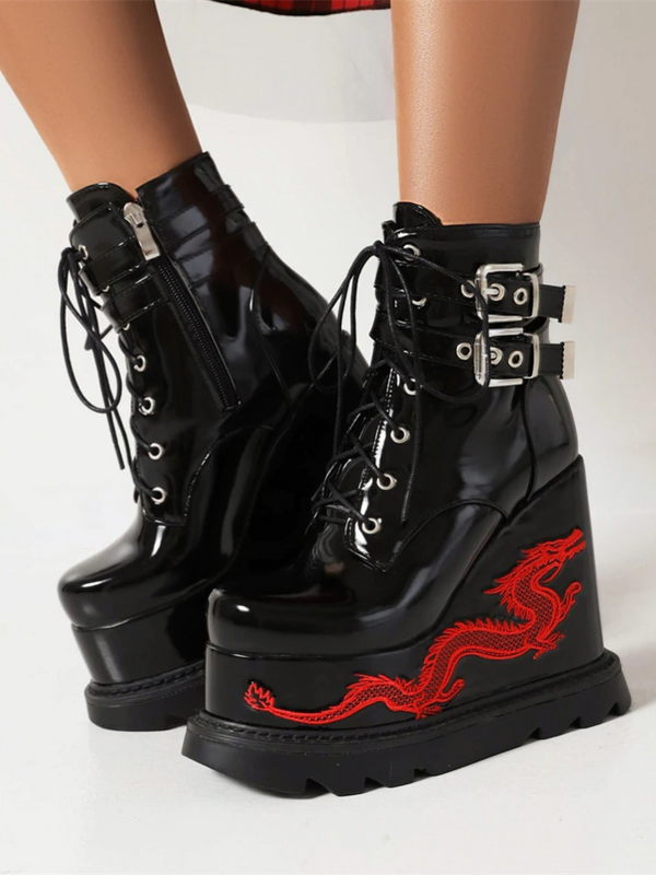 Spitting Fire Platform Boots. These platform boots have a patent vegan leather construction, front lace up closure, side zippers, side buckle closures and platforms with embroidered dragon design.