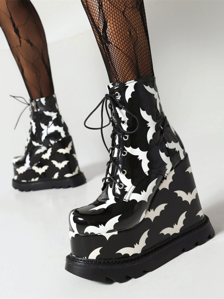 Bat Behavior Platform Boots. These wedge platform boots have a patent vegan leather construction with bat print all over, adjustable lace-ups and side zip closures.